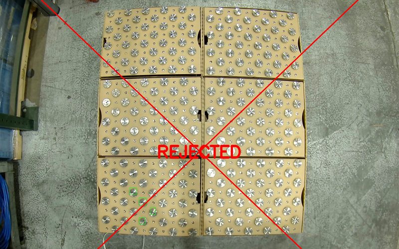 AI quality inspection rejecting defective tray on factory floor